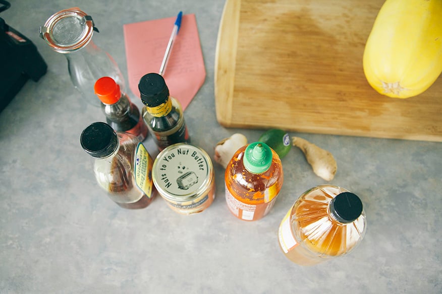 An overhead shot of jars of ingredients for peanut sauce on a naturally lit grey countertop.