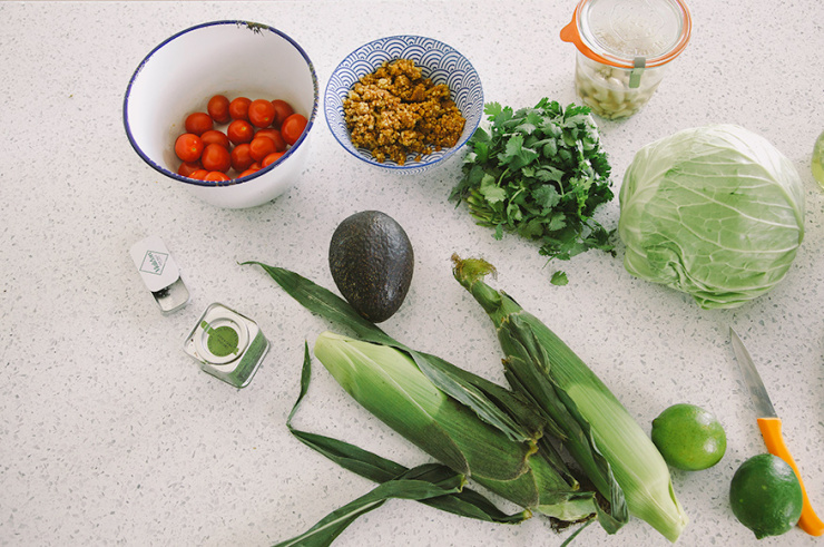 An overhead shot of ingredients for raw and vegan tacos on a white speckled countertop.
