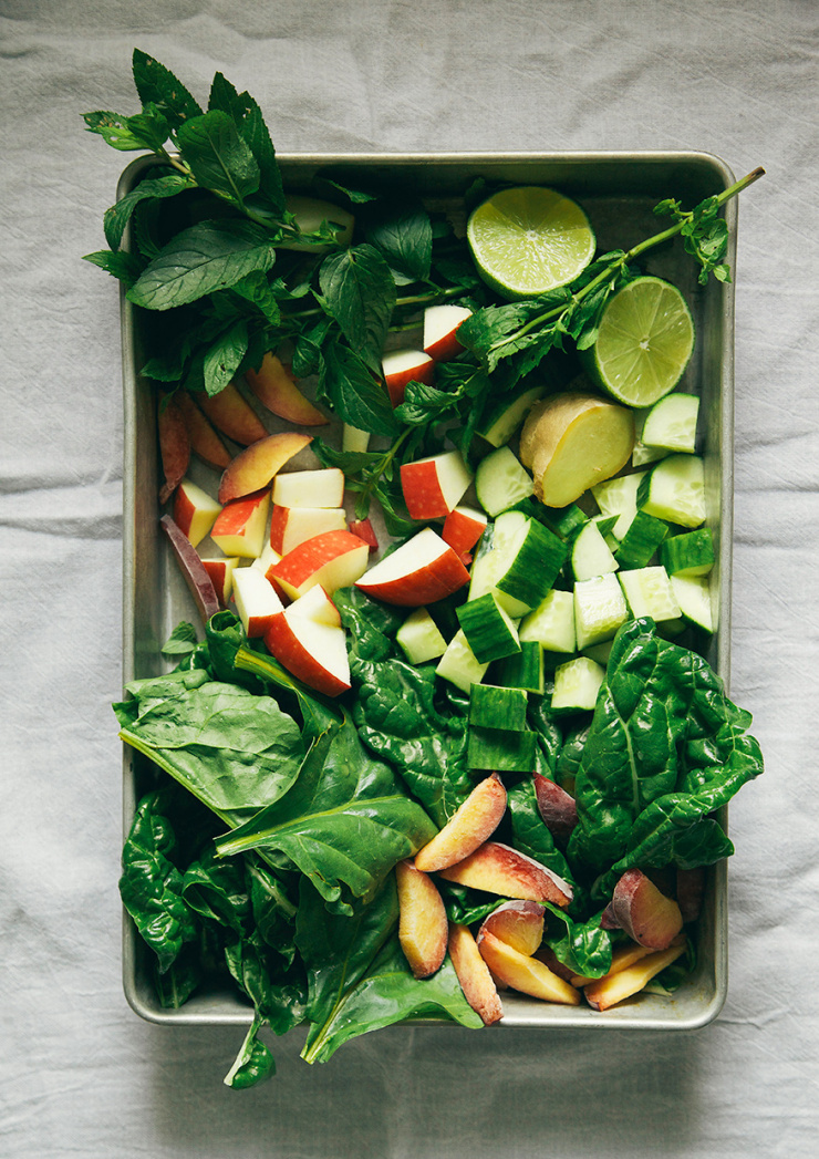 An overhead shot shows a tray with ingredients for a green smoothie.