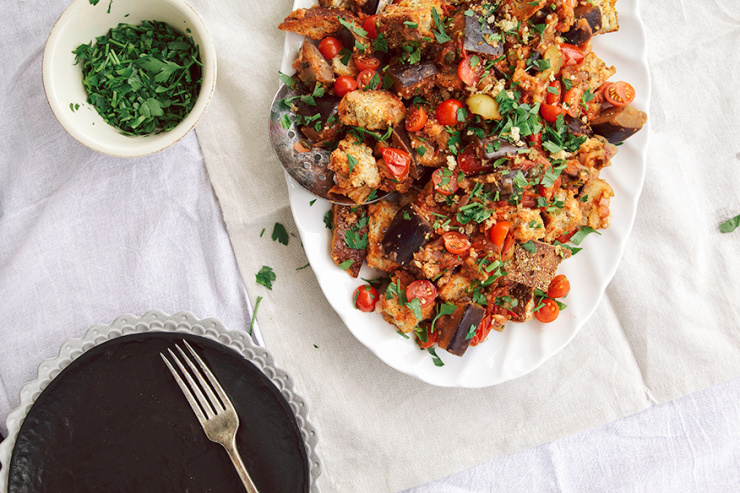 An overhead shot of a caponata panzanella salad on a white platter.