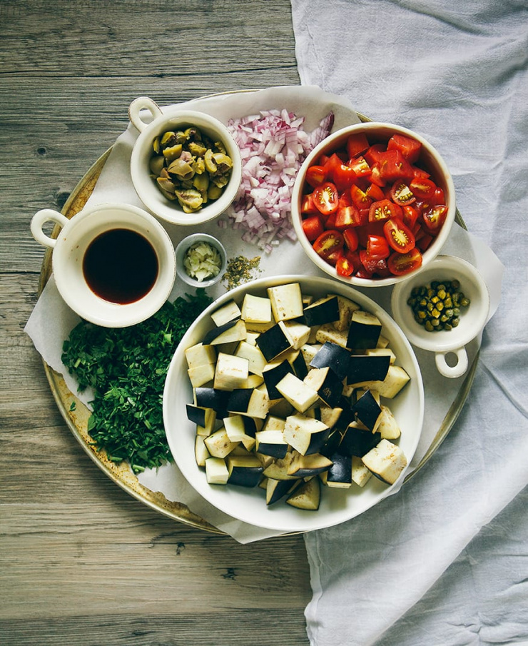 An overhead shot of prepped ingredients used in a caponata panzanella salad.