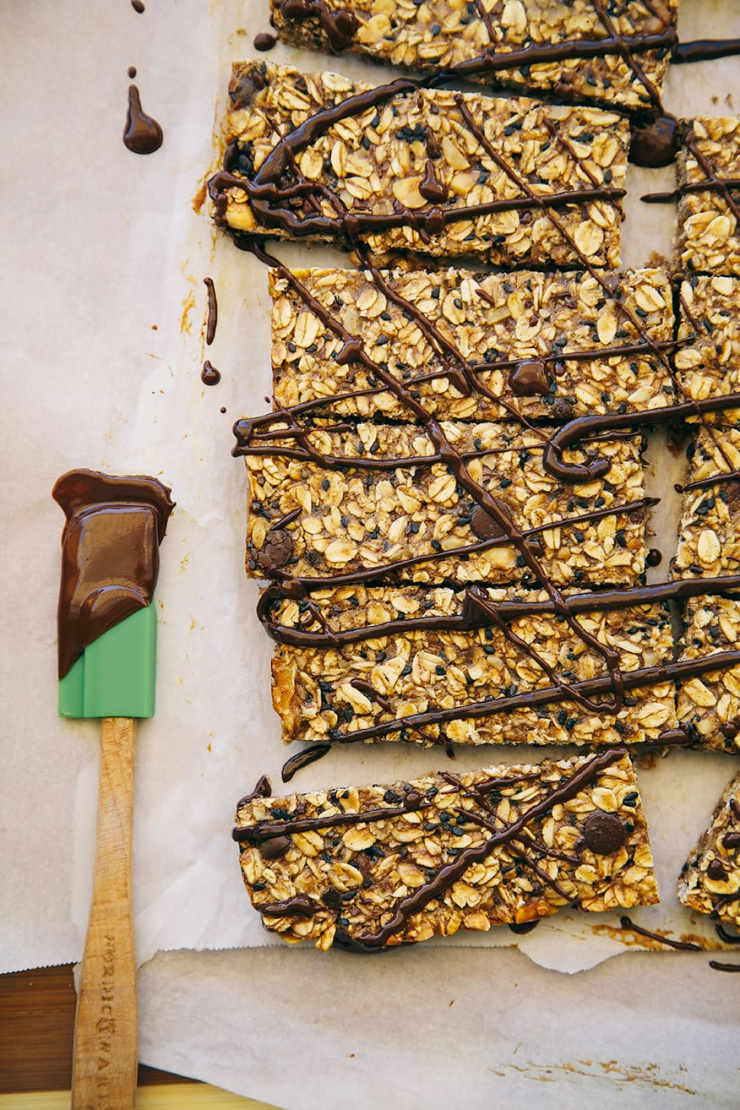 An overhead shot of banana bread granola bars drizzled with melted chocolate.