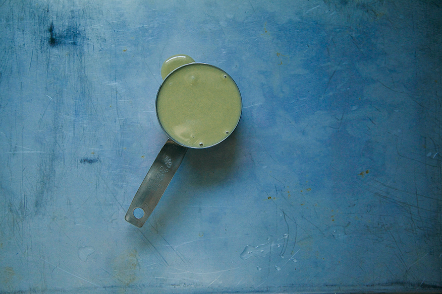 An overhead shot of tahini in a measuring cup.