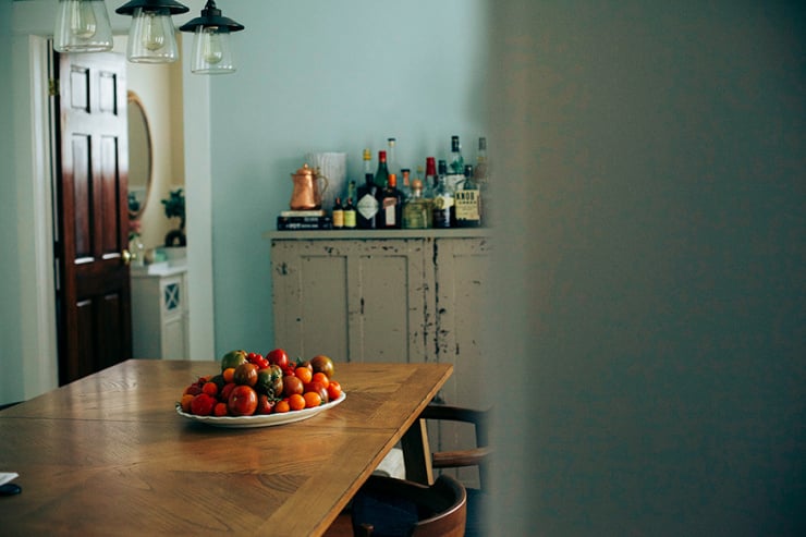 A platter of tomatoes in the middle of a dining table.