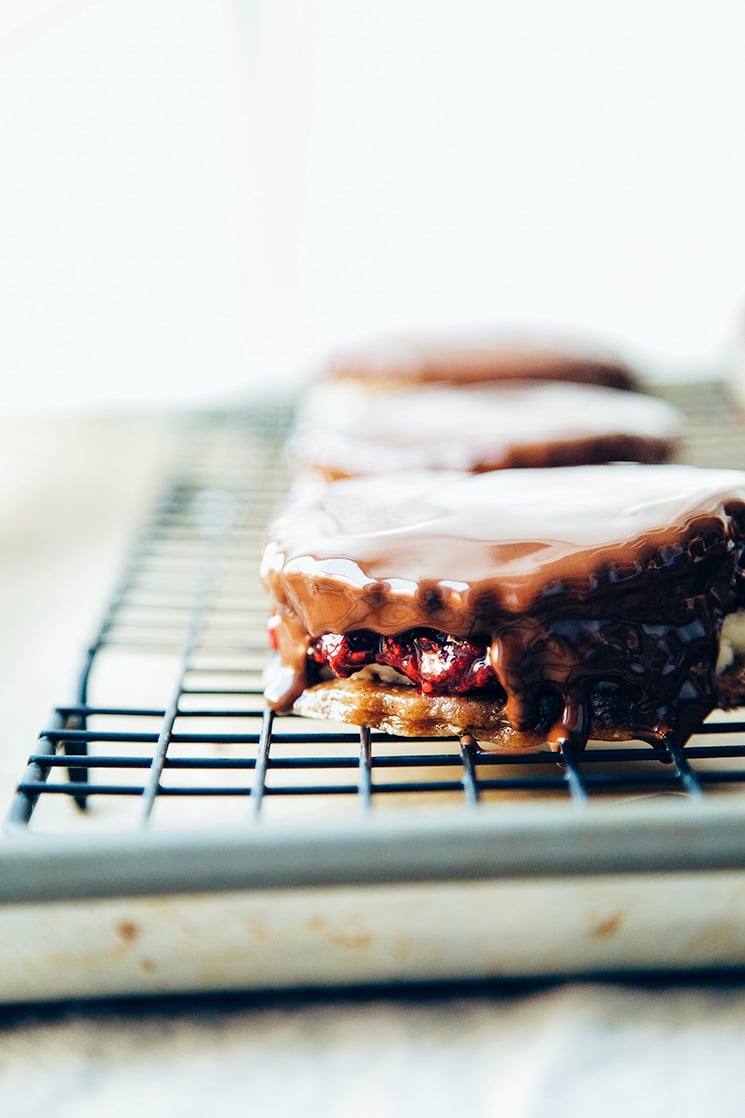 a head-on shot shows vegan wagon wheels with a fresh chocolate coating on a wire rack