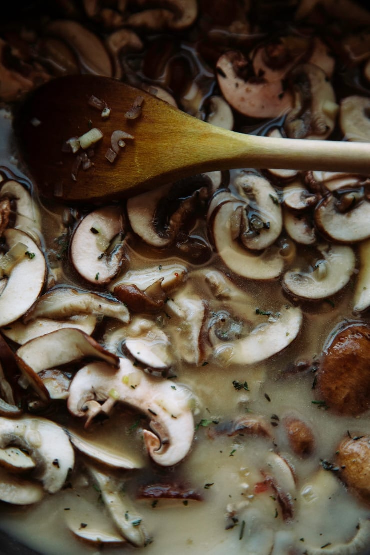 An up close, overhead shot of mushrooms stewing in broth.