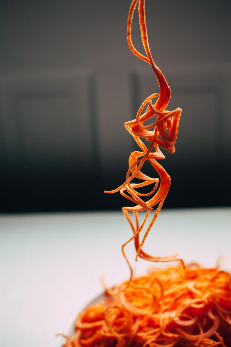 Image shows a sprialized piece of sweet potato dangling from overhead.