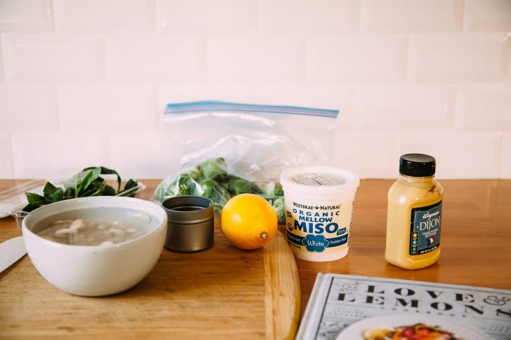 A photo of ingredients for the creamy miso pasta on a wooden countertop with white tile in the background.