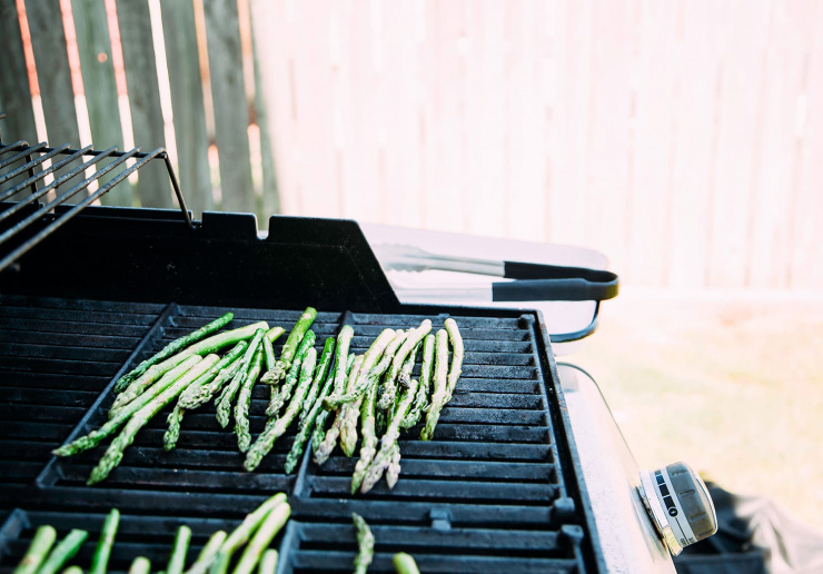 A 3/4 angle shot of asparagus cooking on an outdoor grill