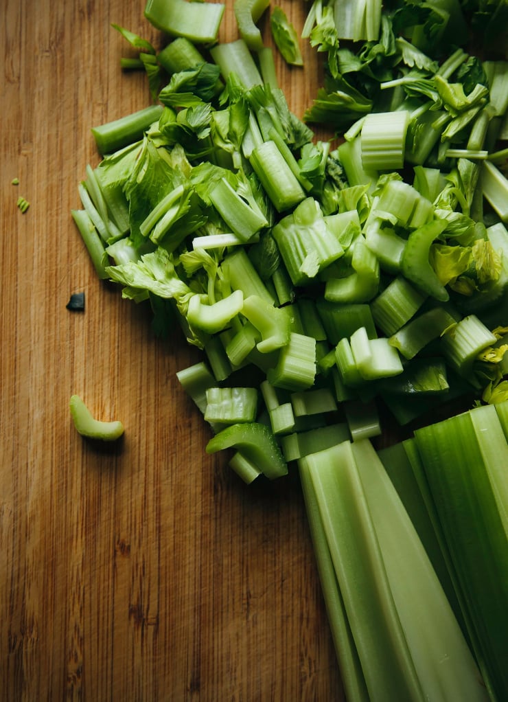 Up close shot of chopped celery on a bamboo cutting board