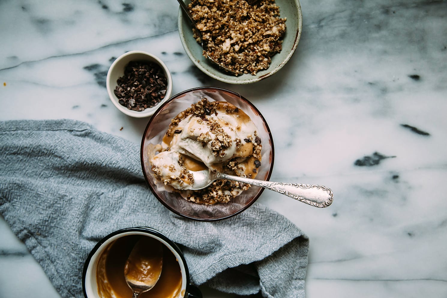 An overhead shot of  vegan peanut caramel sundae in a pink glass bowl.