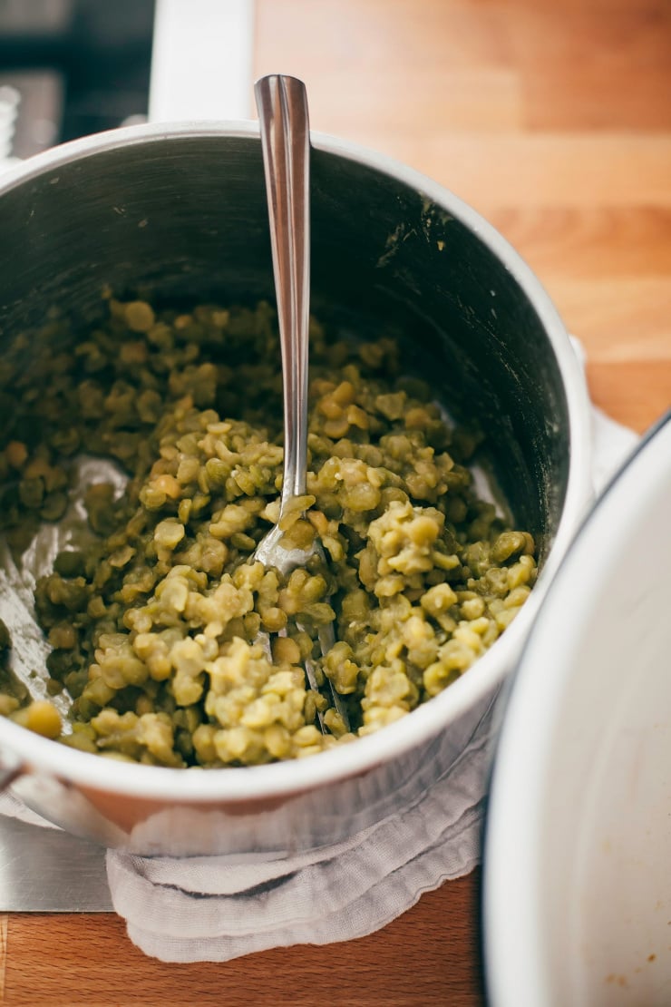 An overhead shot of some cooked split peas in a small saucepan.