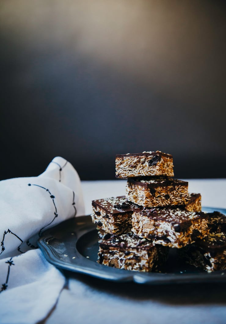 A head on shot of a plate of cut homemade granola bars with a chocolate topping.