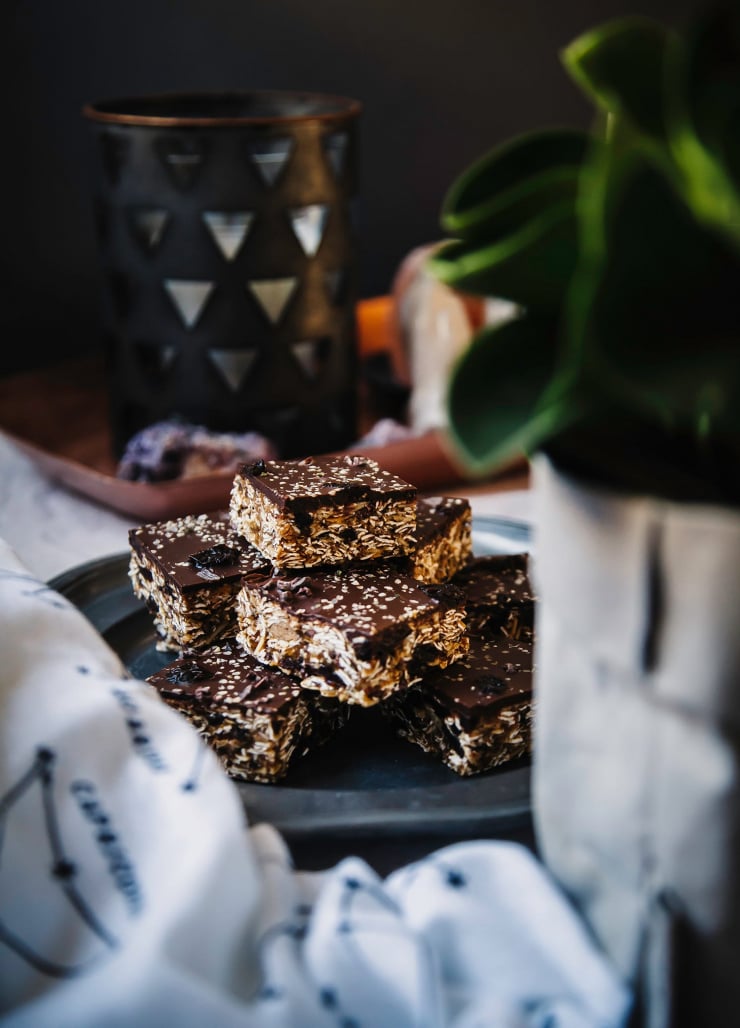 A head on shot of a plate of cut homemade granola bars with a chocolate topping.