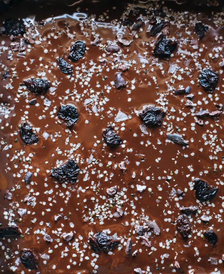 An up close shot of a melted chocolate topping that has been freshly poured onto some oat bars.