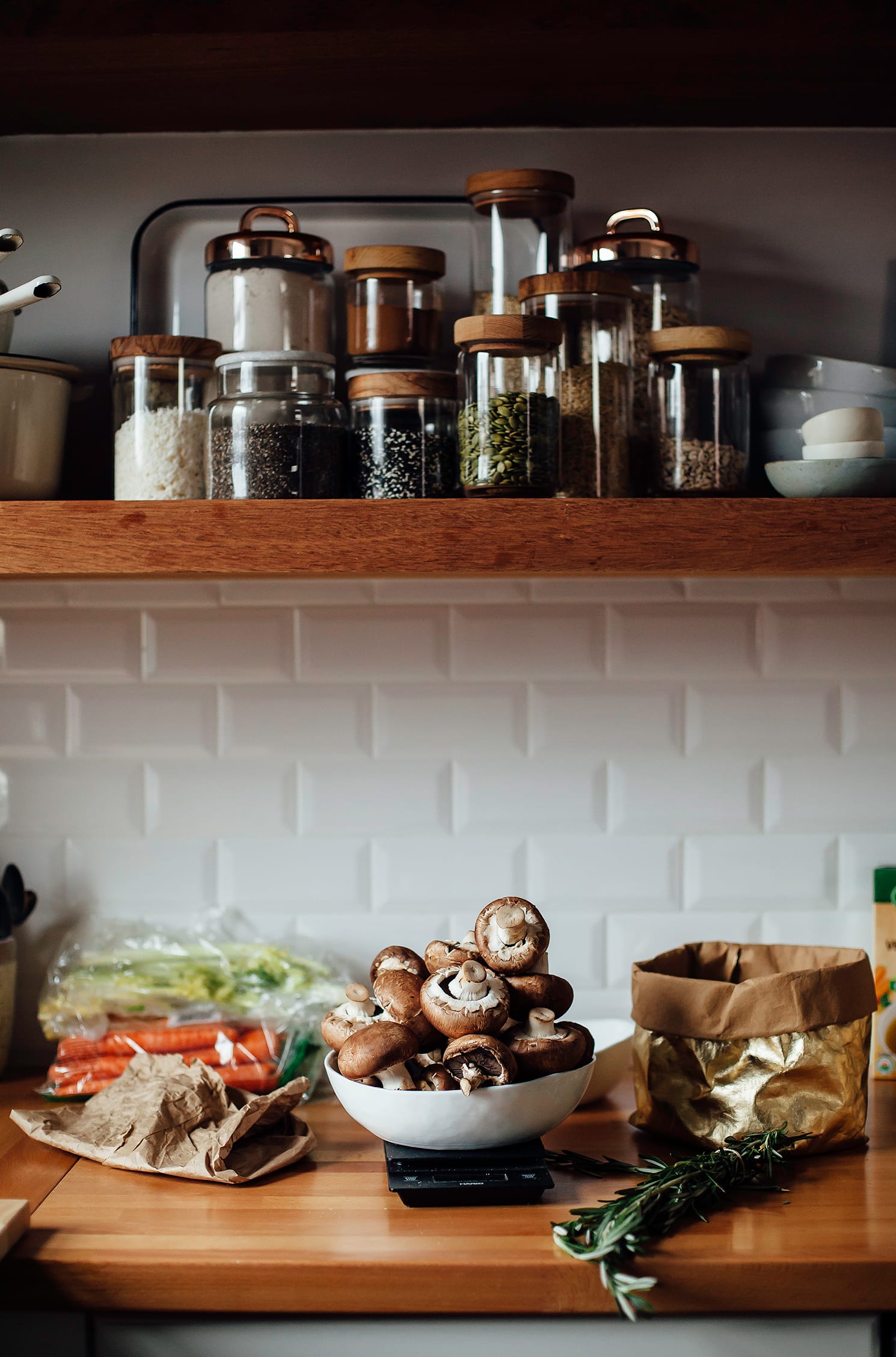 Image shows a kitchen scene with brown creaming mushrooms being weighed on a scale.