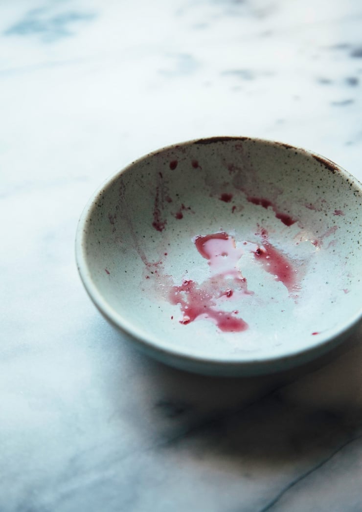 A light blue bowl with stains from some chopped beets.