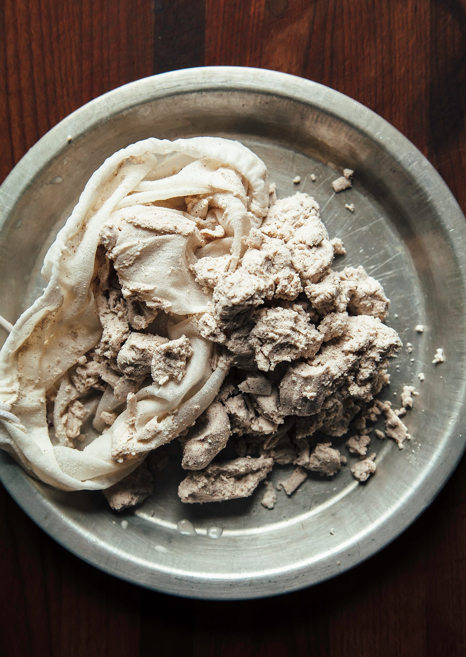 An overhead shot of nut milk pulp in a nut milk straining bag.