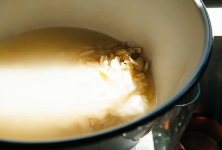 A 3/4 angle shot of almonds soaking in water.