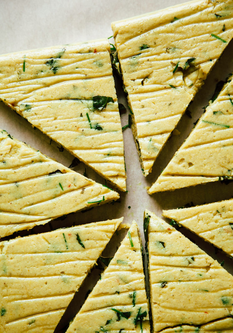 An up close, overhead image of rested polenta cut into triangles.