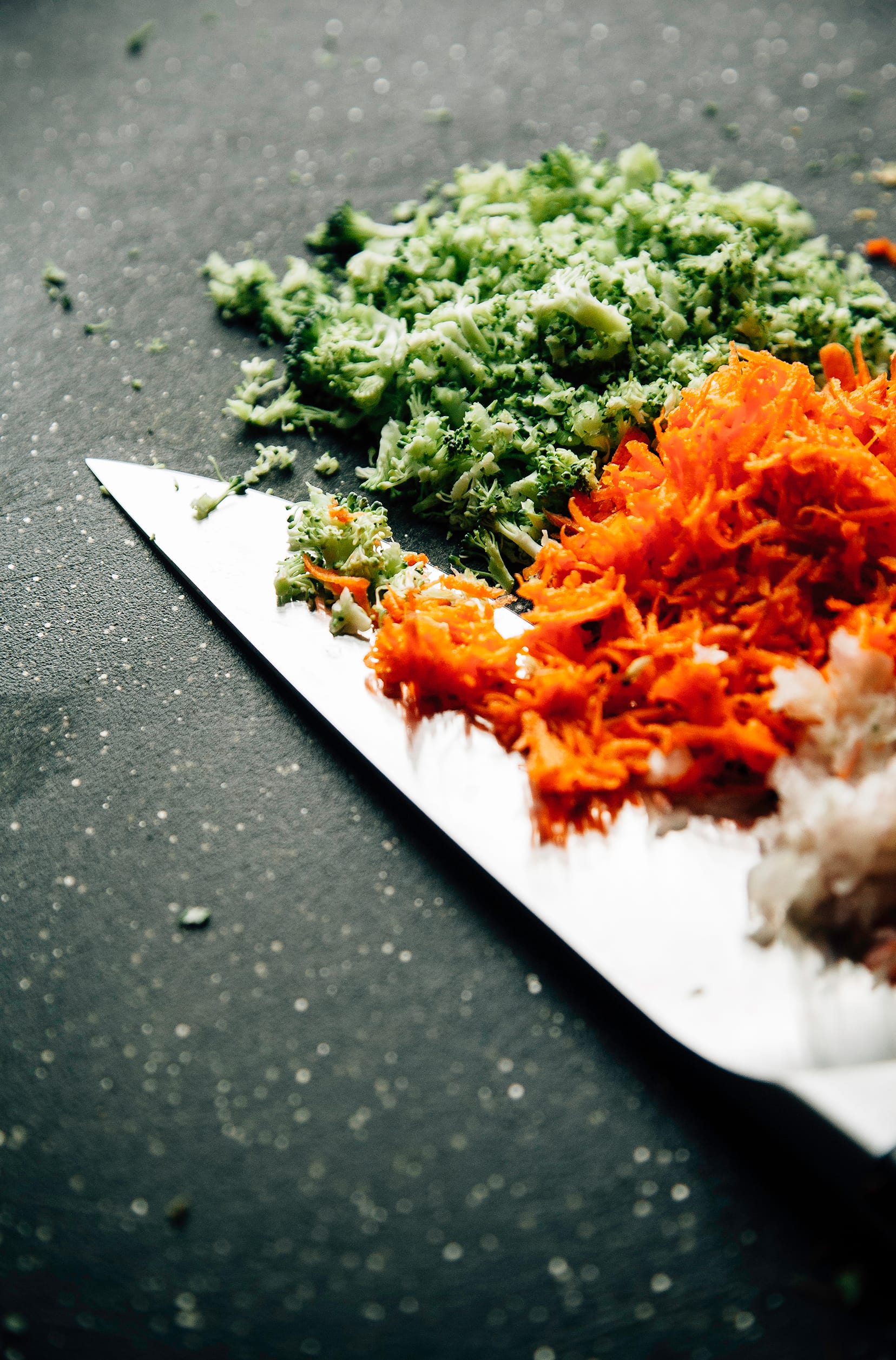 A 3/4 angle image of finely chopped carrots and broccoli.