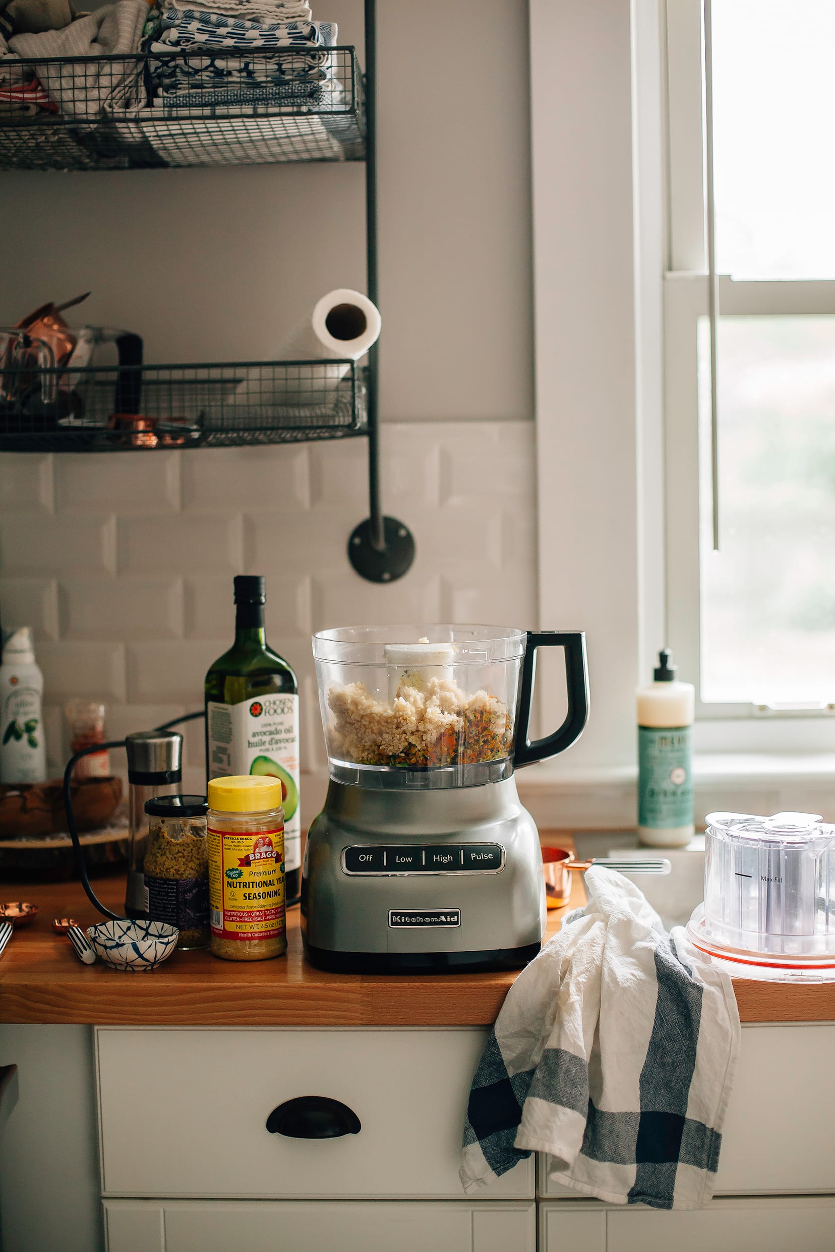 Image shows a kitchen scene with a food processor on the counter along with ingredients for veggie nuggets.