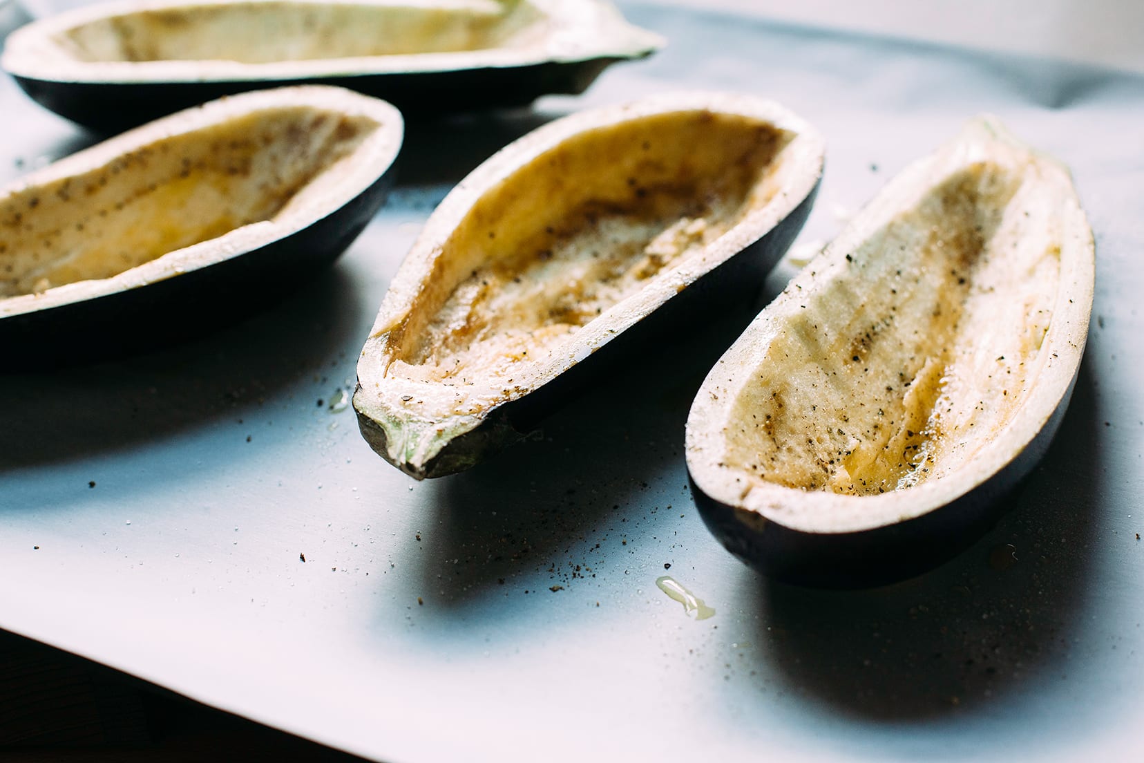 Image shows hollowed out eggplant "shells" on a baking sheet.