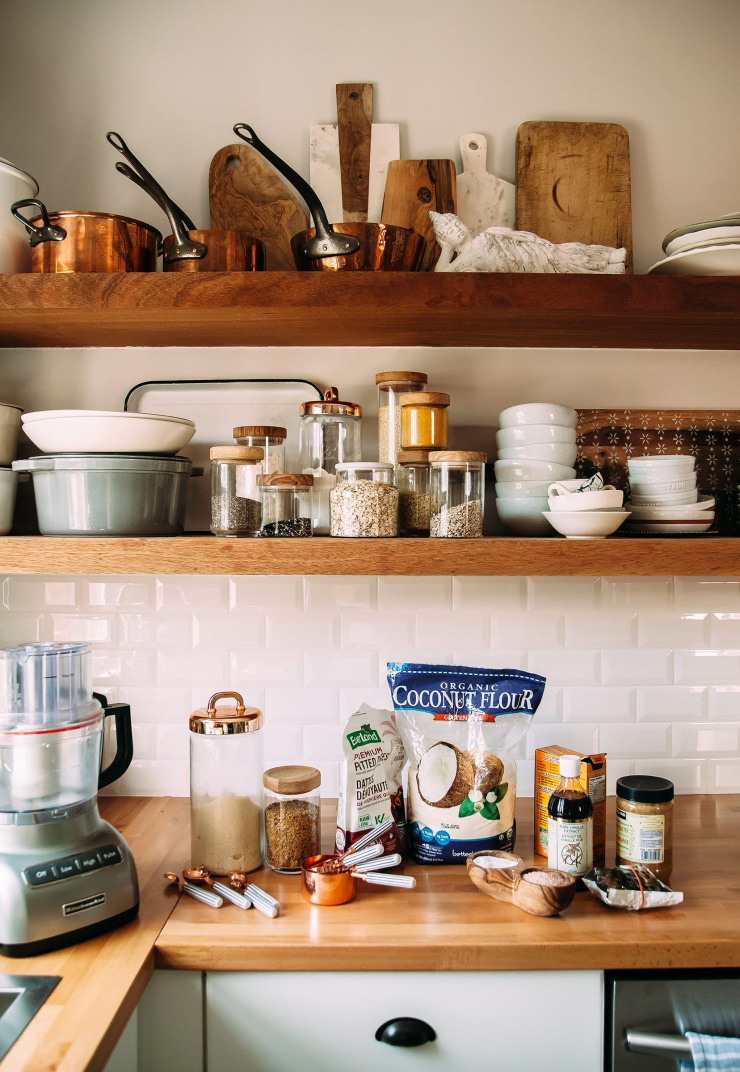 A photo of the open shelves in my kitchen with the cookie ingredients and a grey food processor on the butcher block counter. 
