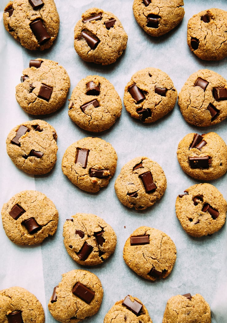An overhead shot of about 20 chocolate chunk Wonder Cookies on white parchment.