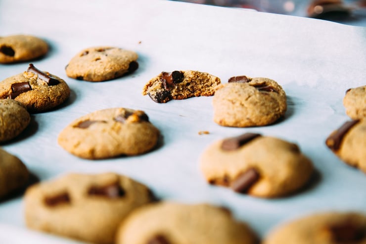 A side angle of chocolate chunk wonder cookies. One of the cookies is split in half to reveal the moist interior.