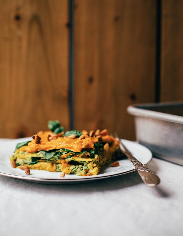 A 3/4 angle shot of a slice of lasagna on a plate.