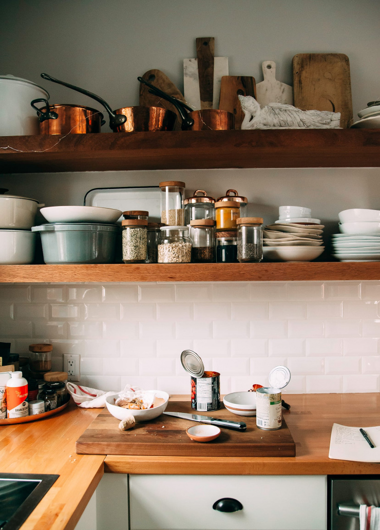 Image shows a kitchen scene with open shelving and canned ingredients open on the counter.