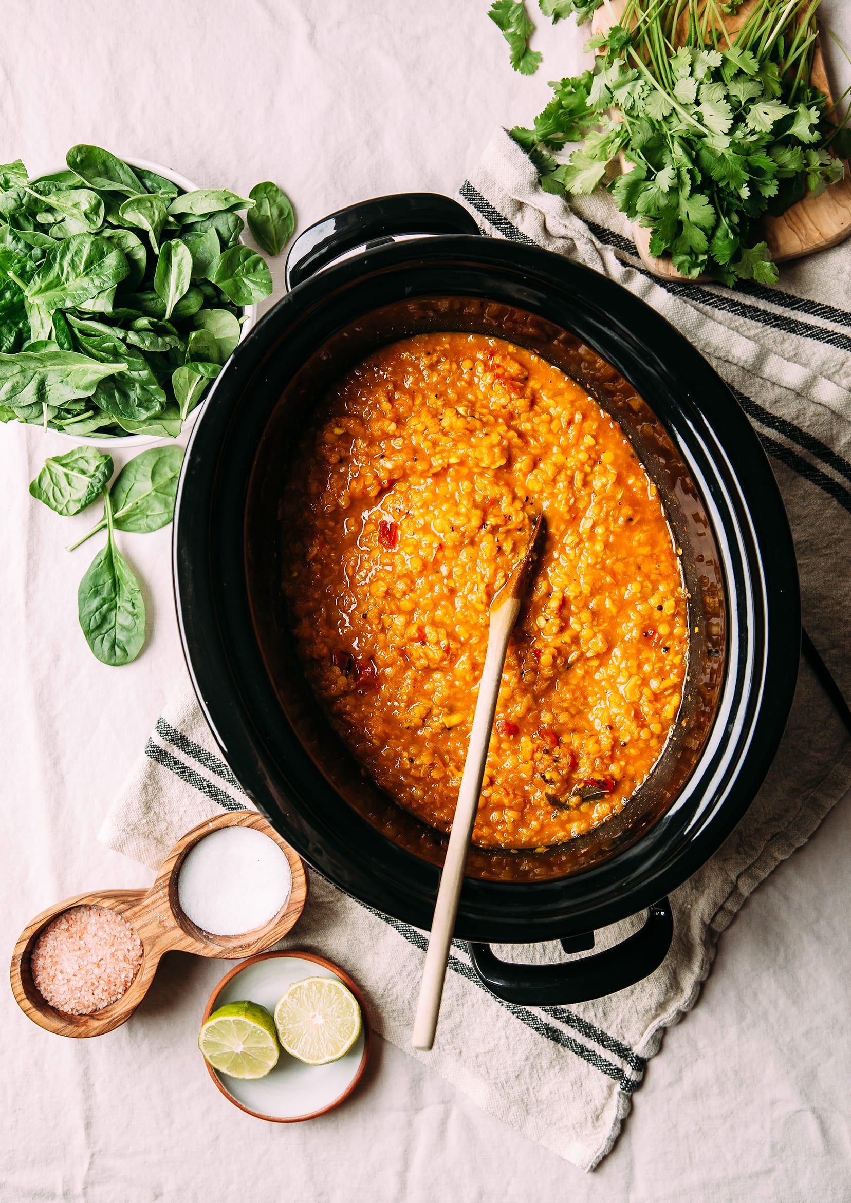 An overhead shot of an orange sweet potato and lentil soup in a slow cooker.