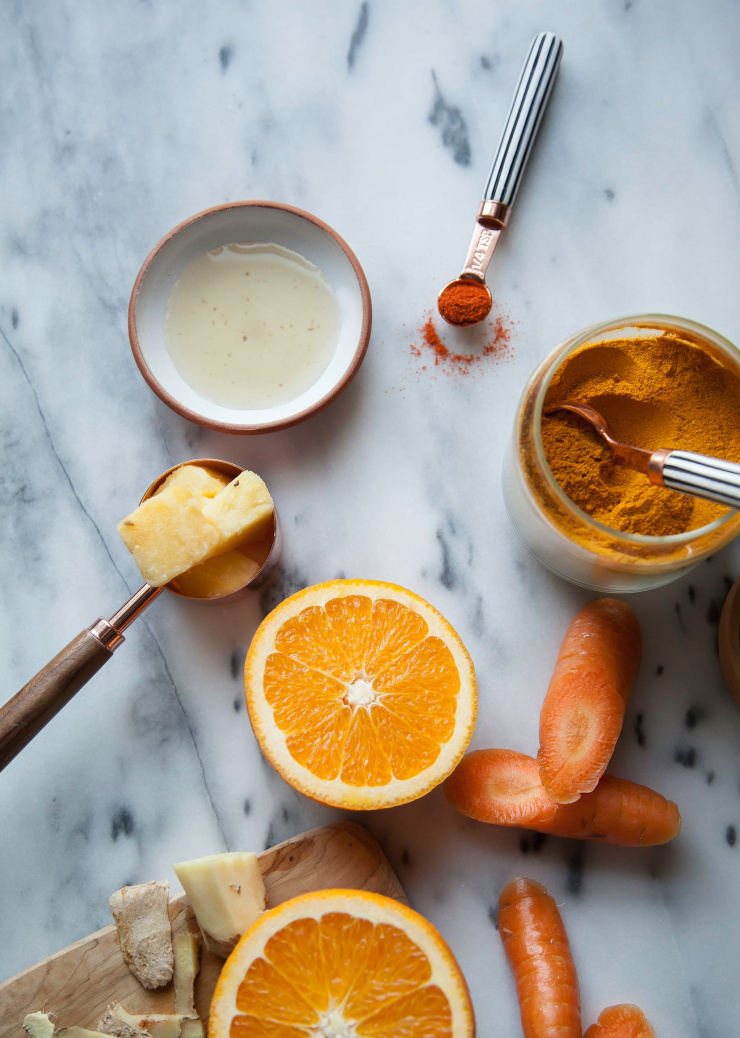 An overhead shot of ingredients for a sweet fire tonic drink on a marble background.