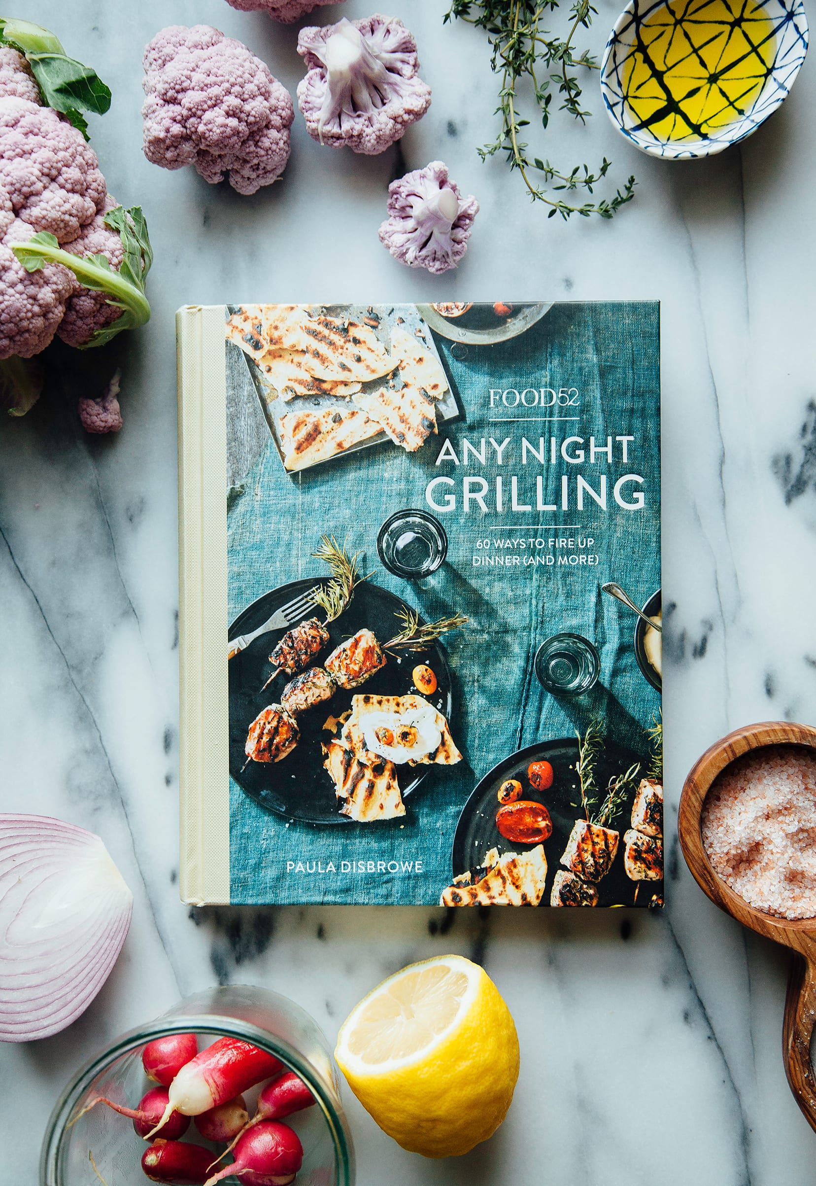 Image shows the "Any Night Grilling" cookbook, facing up on a marble background.