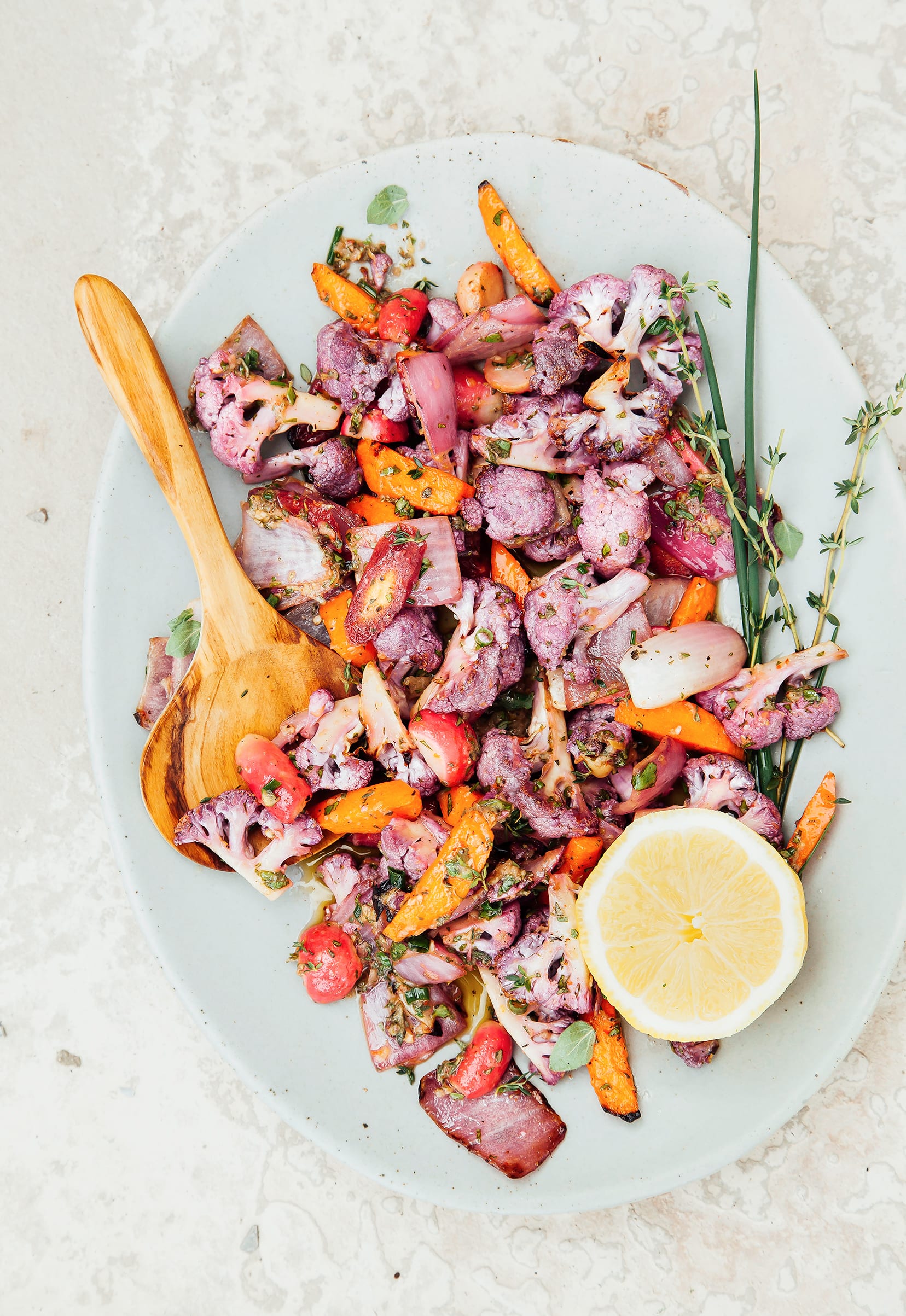 An overhead shot of a plate of grilled and marinated vegetables on a pale blue plate.