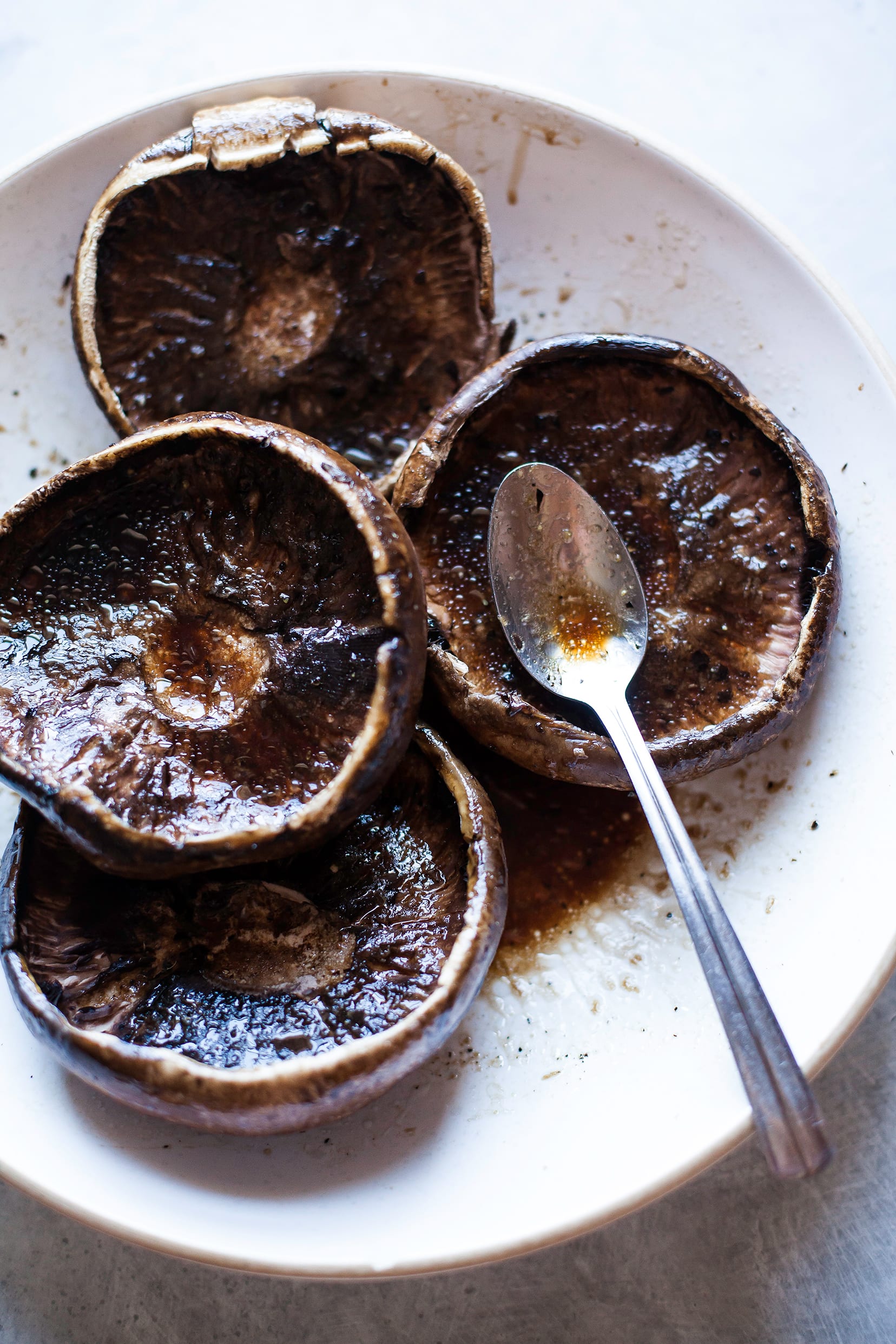 Up close shot of portobello mushroom caps marinating in balsamic vinegar and a few other ingredients.