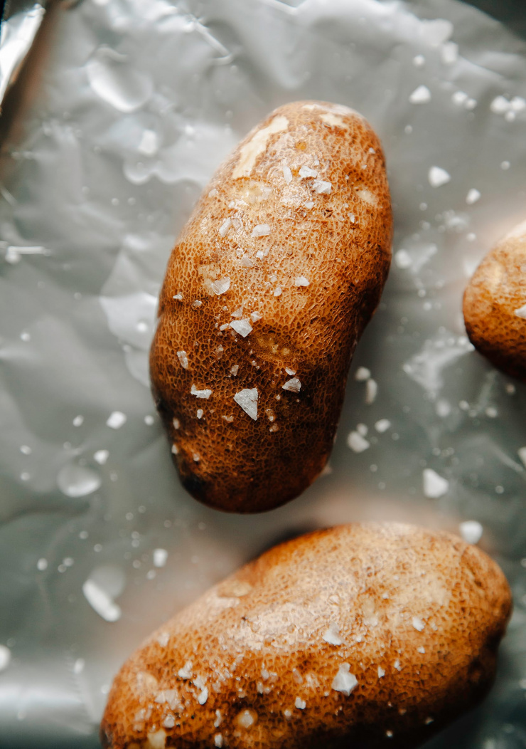 Image shows russet potatoes with a sprinkling of flaky salt on top.