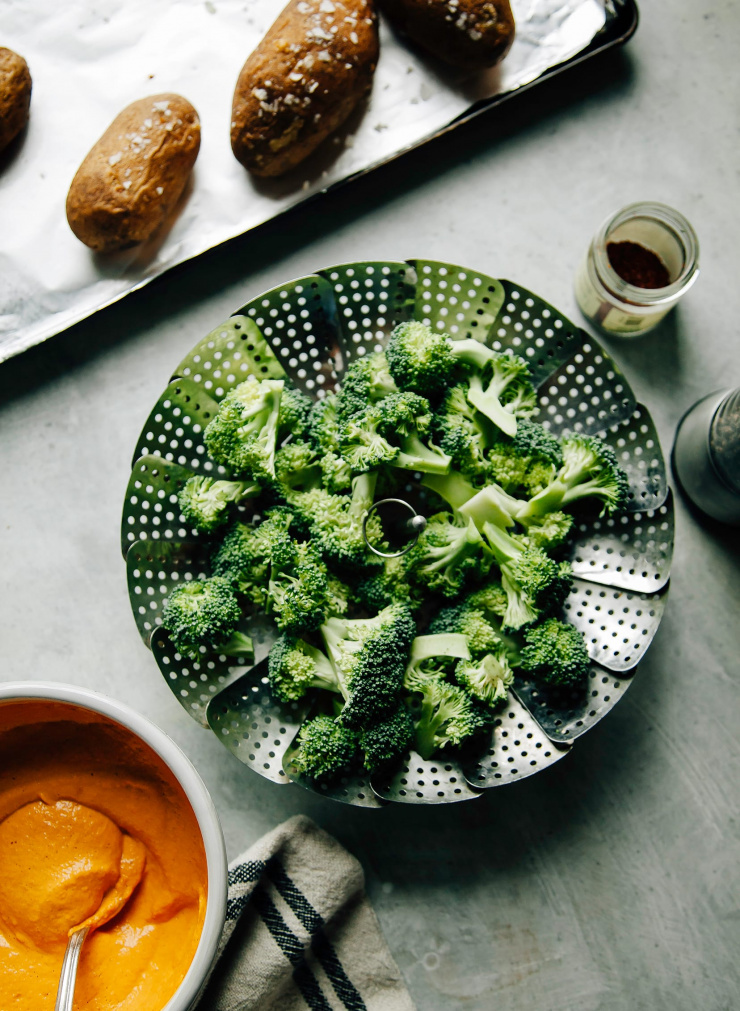 An overhead shot of broccoli florets in a steamer basket.