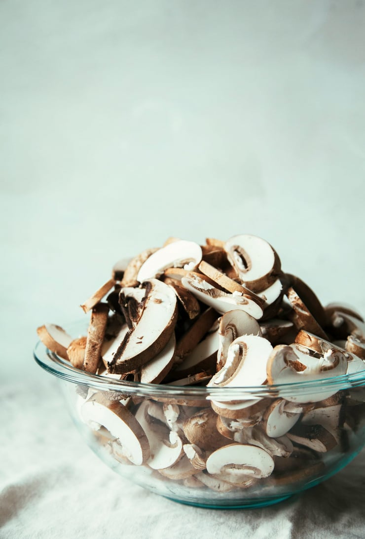 A head-on shot of sliced mushrooms in a bowl.