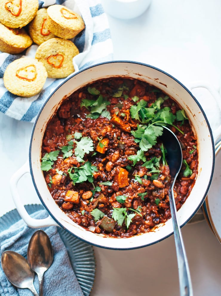 An overhead shot of a deep red smoky squash chili with beans and quinoa.