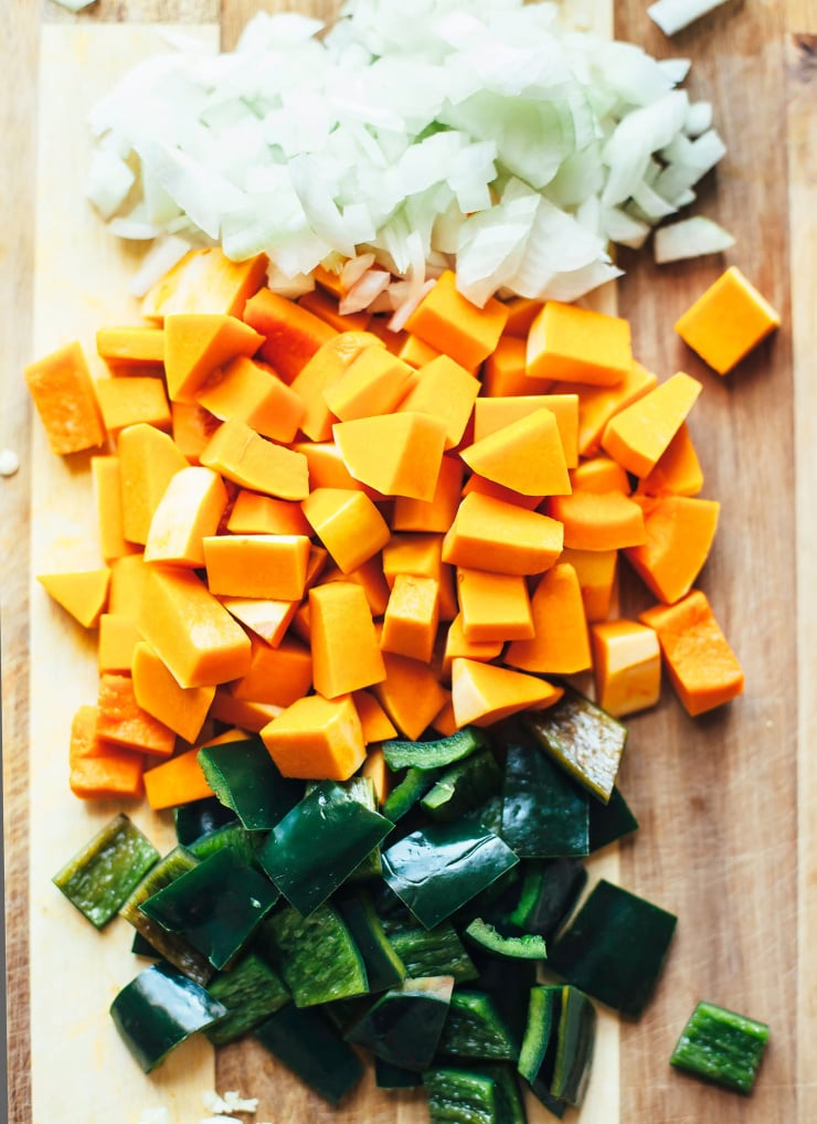 An overhead shot of chopped squash, onions and poblano pepper.