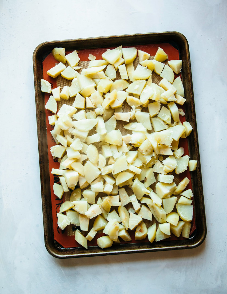 Image shows cooked cubes of root vegetables on a baking sheet.
