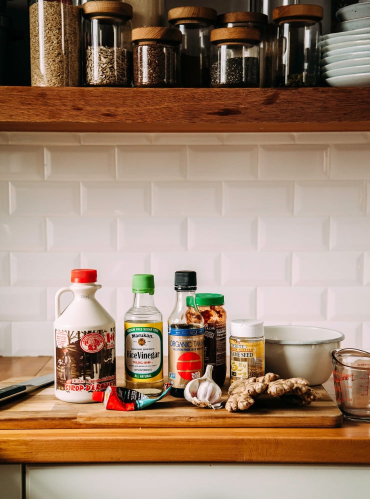 A kitchen counter scene with ingredients for a sesame, ginger, chili sauce.