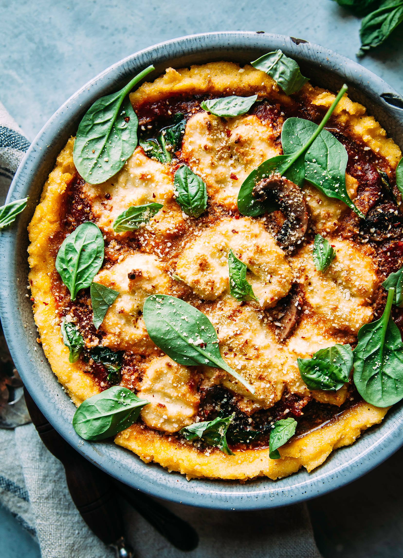 Image shows a baked polenta pie with a deep red tomato and dairy-free ricotta filling.