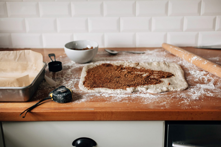 Image shows some rolled out dough with a brown sugar mixture spread on top of the surface of the dough.
