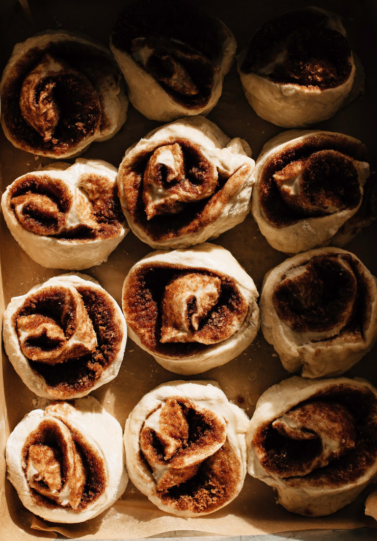Image shows a pan of cinnamon rolls before baking in direct harsh light.
