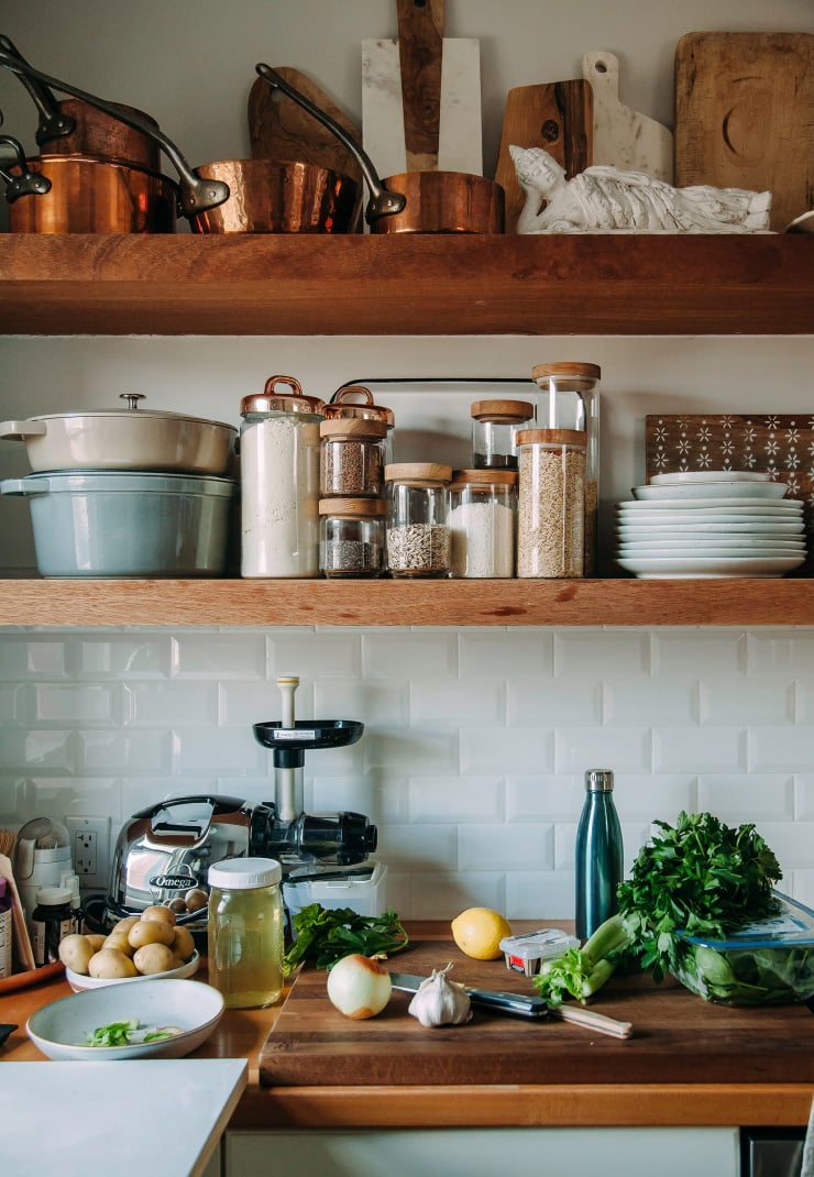 A kitchen scene with vegetables and other stew ingredients out on the counter.