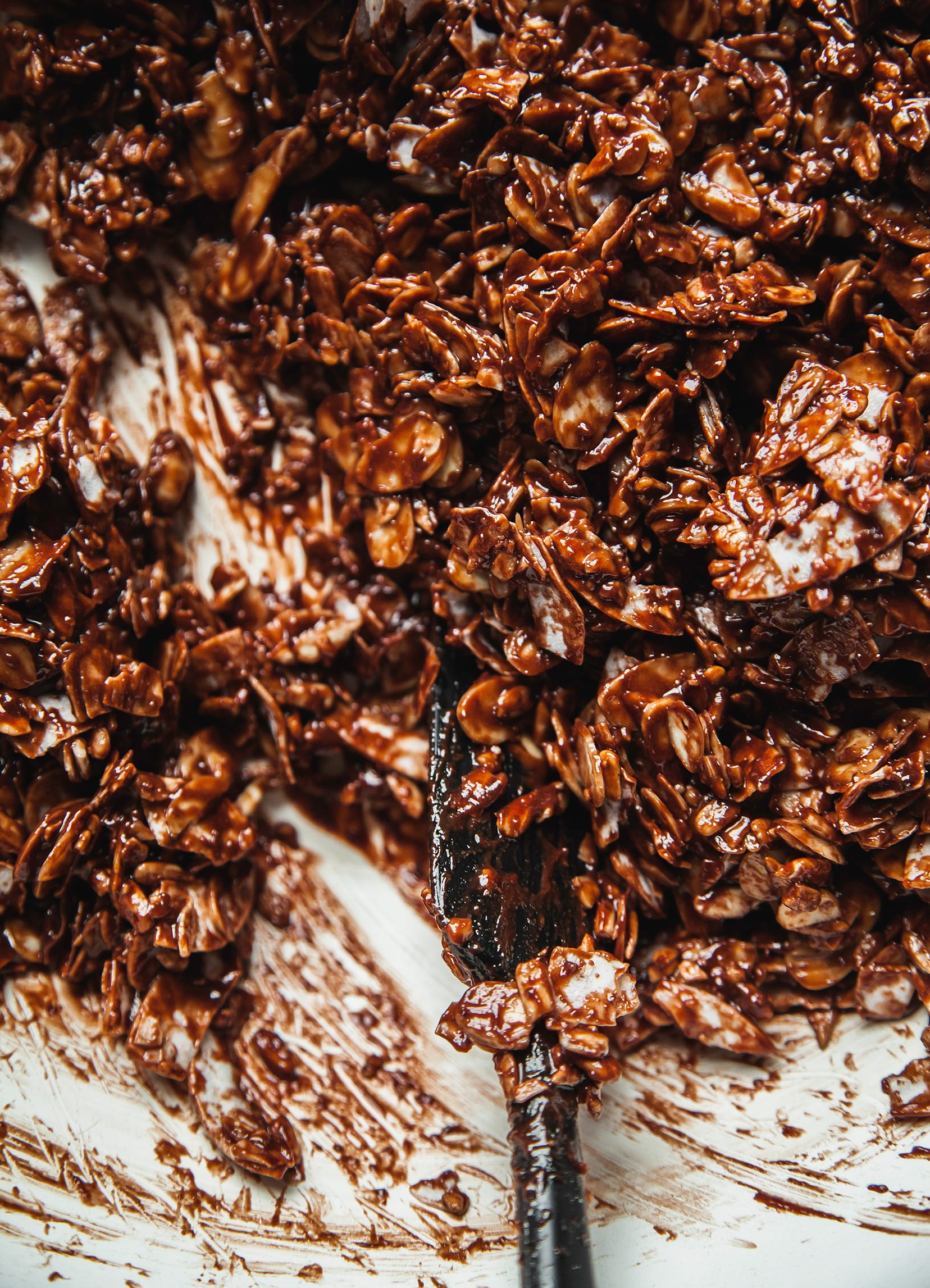 An overhead shot of chocolate sea salt granola being mixed together before baking.