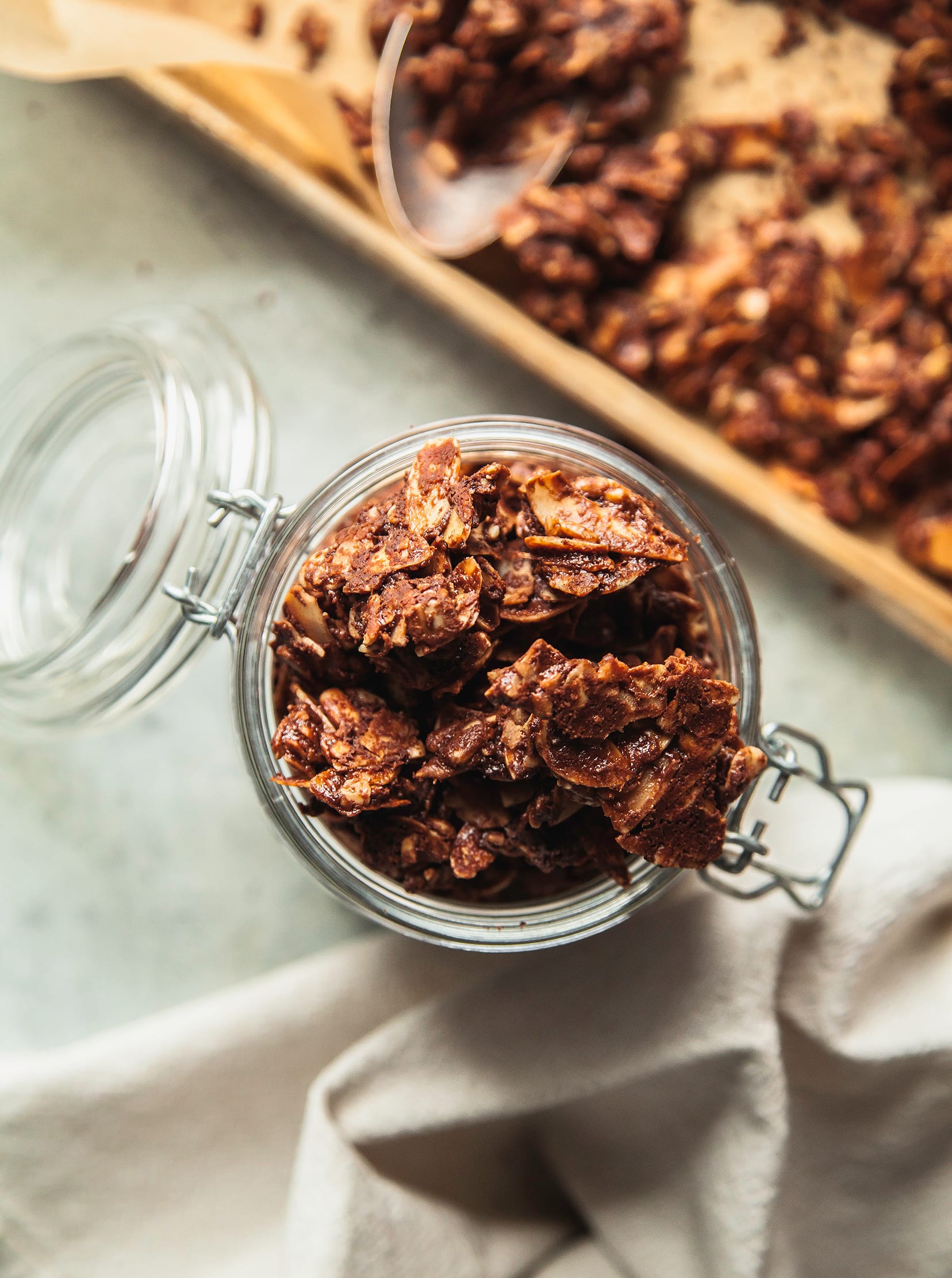 An overhead shot of granola chunks in a glass jar.